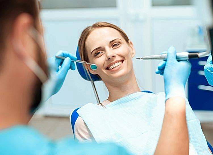 woman-sits-dental-chair-doctors-bowed-her